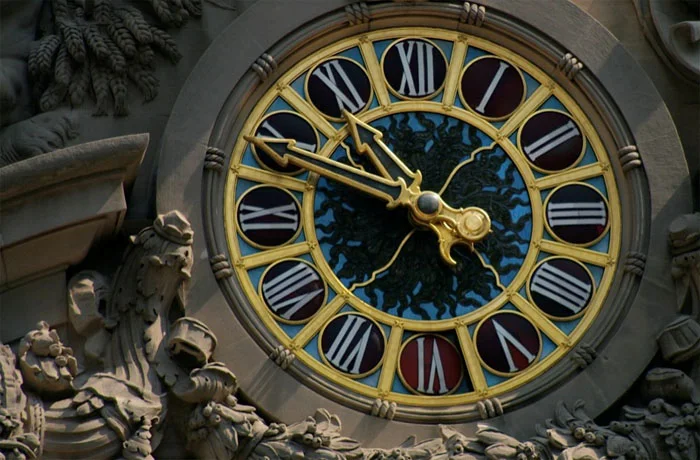 The Tiffany glass clock face at Grand Central Terminal, gilded Roman numerals on coloured glass.
