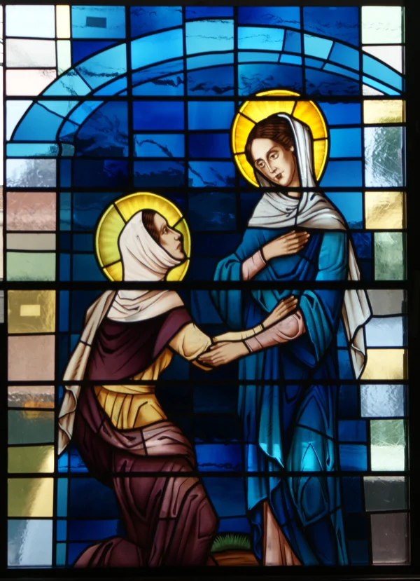 A blue stained glass lancet showing two robed figures meeting.